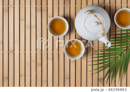 White teapot and tea cups with tea drink top view. White teapot and tea cups with tea drink top view. 86296863