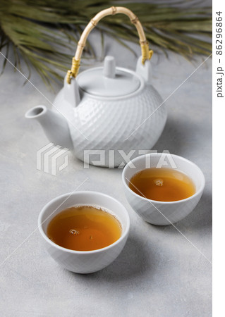 Asian tea ceremony. Teapot and tea cups with tea drink on table. Asian tea ceremony. Teapot and tea cups with tea drink on table. 86296864