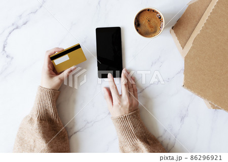 Woman hands holding credit card and ordering pizza online. Woman hands holding credit card and ordering pizza online. 86296921