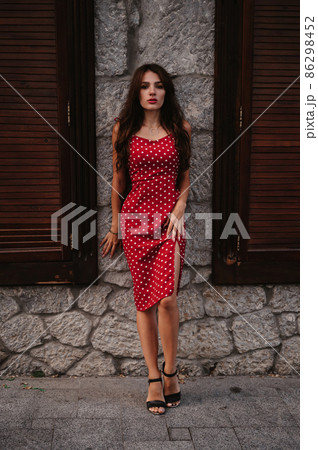 attractive brunette girl with sexy figure poses on beautiful ancient European street 86298452