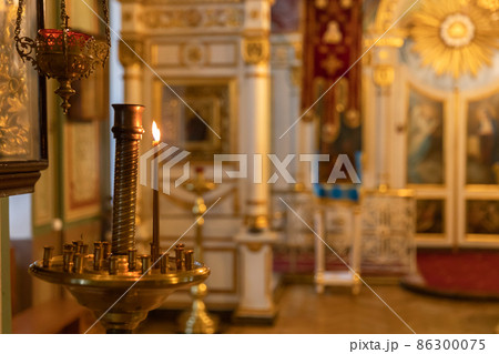 Orthodox Church. Christianity. Festive interior decoration with burning candles and icon in traditional Orthodox Church on Easter Eve or Christmas. Religion faith pray symbol Orthodox Church. Christianity. Festive interior decoration with burning candles and icon in traditional Orthodox Church on Easter Eve or Christmas. Religion faith pray symbol 86300075