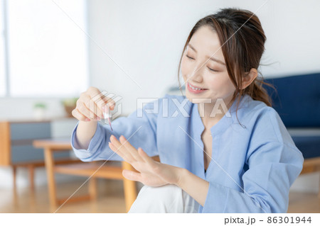リビングでマニキュアを塗る若い女性 リビングでマニキュアを塗る若い女性 86301944