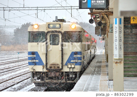粉雪の舞う東能代駅に停車中の五能線カラーのキハ40系48型気動車です 86302299