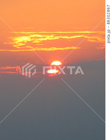 遠くの空に沈んでいく真っ赤な夕日 遠くの空に沈んでいく真っ赤な夕日 86302867