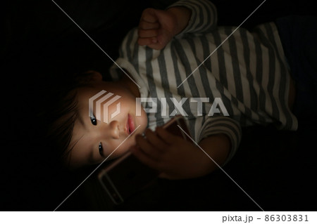 暗い中でスマートフォンを使う男の子 86303831
