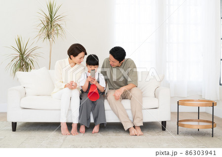 テレビでスポーツ観戦する親子3人のファミリー テレビでスポーツ観戦する親子3人のファミリー 86303941