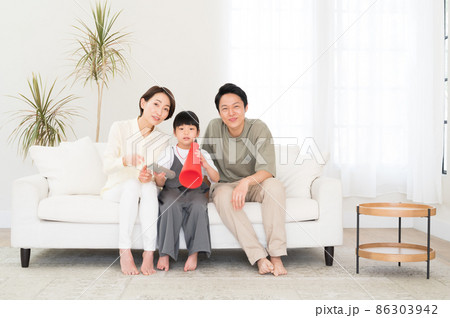 テレビでスポーツ観戦する親子3人のファミリー 86303942