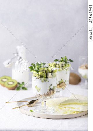 Homemade yogurt with fresh kiwi, muesli and mint 86304945