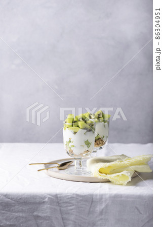 Homemade yogurt with fresh kiwi, muesli and mint Homemade yogurt with fresh kiwi, muesli and mint 86304951