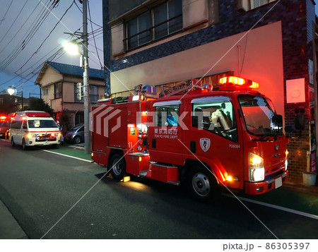 夜間に緊急出動する消防車両 86305397