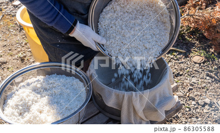正月準備の餅つき（洗米したもち米を蒸し布に入れる） 86305588