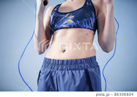 Smiling sportswoman posing with a skipping rope. Female with muscular body posing with jump rope. Fitness model. Body positivity, sport, fitness concept. Healthy lifestyle. Fit woman with jump rope 86306804