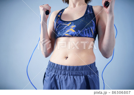 Smiling sportswoman posing with a skipping rope. Female with muscular body posing with jump rope. Fitness model. Body positivity, sport, fitness concept. Healthy lifestyle. Fit woman with jump rope 86306807