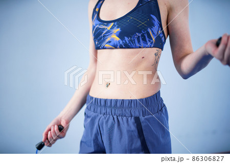 Fit woman with jump rope posing in the gym. Sport exercises healthy lifestyle concept. Sporty happy woman with skipping rope posing to the camera. Active lifestyle concept. Healthy lifestyle 86306827