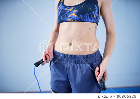 Smiling sportswoman posing with a skipping rope. Female with muscular body posing with jump rope. Fitness model. Body positivity, sport, fitness concept. Healthy lifestyle. Fit woman with jump rope 86306829