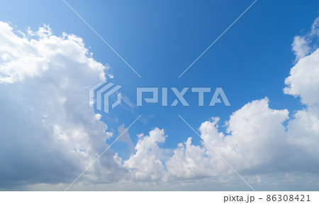 Clear blue sky with white fluffy clouds at noon. Day time. Abstract nature landscape background. Clear blue sky with white fluffy clouds at noon. Day time. Abstract nature landscape background. 86308421