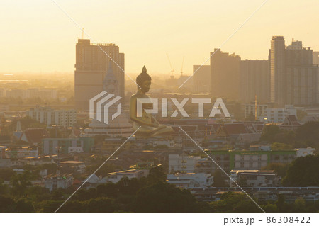 Aerial view of the Giant Golden Buddha in Wat Paknam Phasi Charoen Temple in Phasi Charoen district on Chao Phraya River at sunset, Bangkok. Urban town, Thailand. Downtown City. 86308422