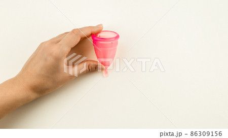 Woman hand holding a pink menstrual cup Woman hand holding a pink menstrual cup 86309156