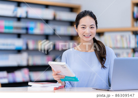 本を貸し出す図書館司書　撮影協力：中央工学校附属日本語学校 86309547