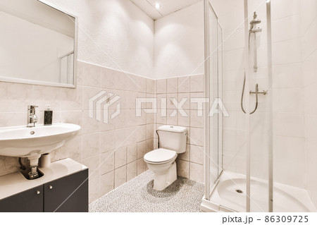 Spectacular bathroom design with beige tiled walls and toilet 86309725