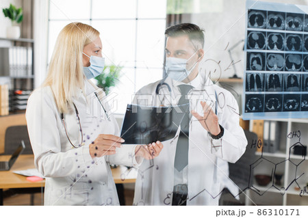 Doctors in face masks analysing x ray scan at hospital 86310171
