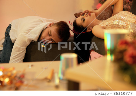 Drunk couple sleeping in messy room after New Year party 86310777