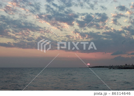 Sunrise over the sea in Kokkini Hani, Crete, Greece. Scenic seaside landscape in the cloudy morning. 86314646