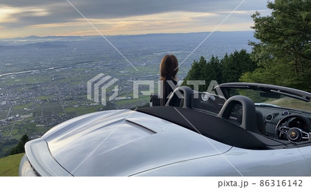 オープンカーと山頂から朝焼けを望む オープンカーと山頂から朝焼けを望む 86316142