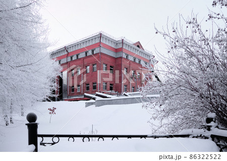 Snow-covered trees around the Khabarovsk Museum of Local Lore after heavy snowfall in the morning at sunrise. Trees in the snow. Russia, the Far East. Snow-covered trees around the Khabarovsk Museum of Local Lore after heavy snowfall in the morning at sunrise. Trees in the snow. Russia, the Far East. 86322522