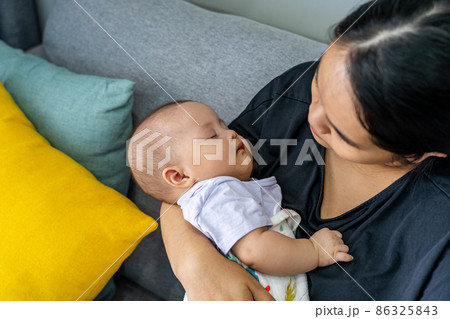 Adorable baby girl sleeping on her mother's hand Adorable baby girl sleeping on her mother's hand 86325843
