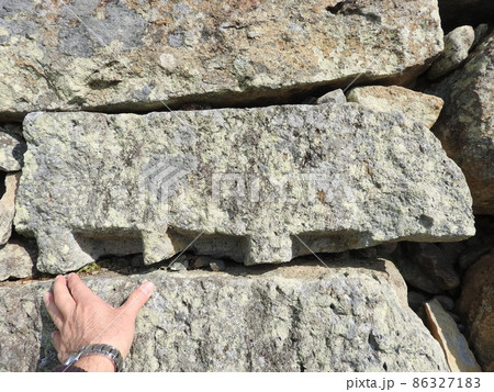 城の石垣に使った石の割った跡「矢穴(クサビの跡)」:手を添えた大きさの分かる写真 城の石垣に使った石の割った跡「矢穴(クサビの跡)」:手を添えた大きさの分かる写真 86327183