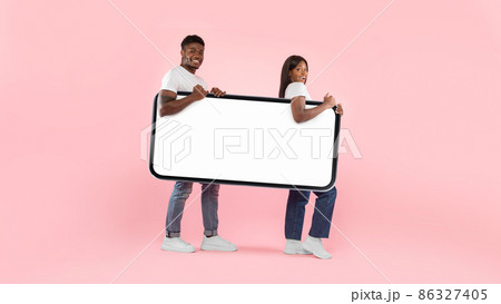 Excited black couple walking with big white empty smartphone screen 86327405
