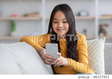 Cute asian girl schooler playing games on cellphone, panorama 86327952
