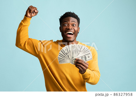 Emotional black guy with cash celebrating success Emotional black guy with cash celebrating success 86327958