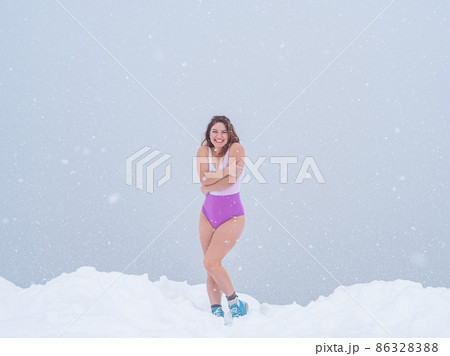Caucasian woman is freezing outdoors in winter and hugging herself with her arms. Caucasian woman is freezing outdoors in winter and hugging herself with her arms. 86328388
