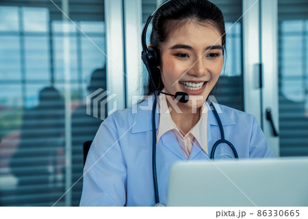 Doctor wearing headset talking actively on video call in hospital or clinic 86330665
