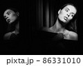 Beautiful young woman near a glass in interior 86331010