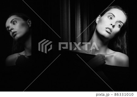 Beautiful young woman near a glass in interior 86331010