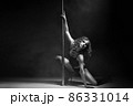 Young slim pole dance woman exercising over dark 86331014