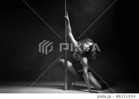 Young slim pole dance woman exercising over dark 86331014
