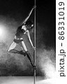 Young slim pole dance woman exercising over dark 86331019