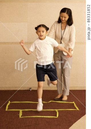 お受験の行動観察テスト、運動の実技を受ける女の子と試験官 お受験の行動観察テスト、運動の実技を受ける女の子と試験官 86331852