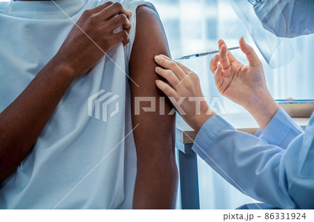 Young man visits skillful doctor at hospital for vaccination Young man visits skillful doctor at hospital for vaccination 86331924