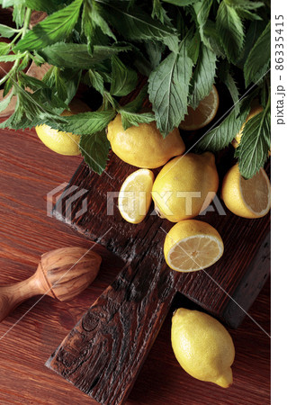 Fresh juicy lemons with mint on the old wooden table. 86335415