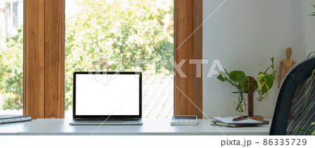 Blank screen laptop computer in minimal office room with calculatpr and decorations and copy space. Blank screen laptop computer in minimal office room with calculatpr and decorations and copy space. 86335729