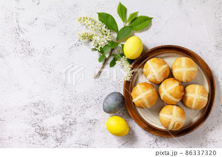 Easter baking. Homemade Easter traditional hot cross buns on a gray stone tabletop. Top view flat lay background. Copy space. Easter baking. Homemade Easter traditional hot cross buns on a gray stone tabletop. Top view flat lay background. Copy space. 86337320