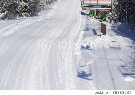 朝一ピステンの入ったきれいなコースをリフトから眺める人 86338239