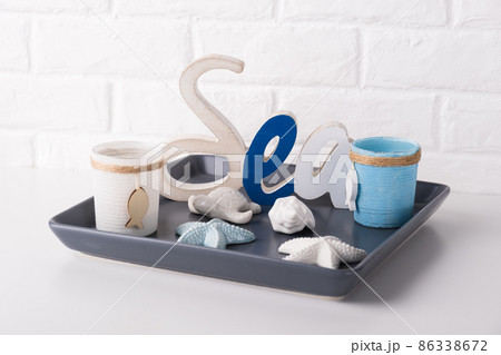 Marine nautical decoration theme in interior. Decorative inscription sea and blue candle holders. 86338672