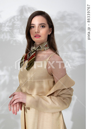 Young woman in beige dress with shadow behind Young woman in beige dress with shadow behind 86339767
