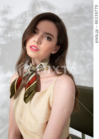 Young woman in beige dress with shadow behind 86339770